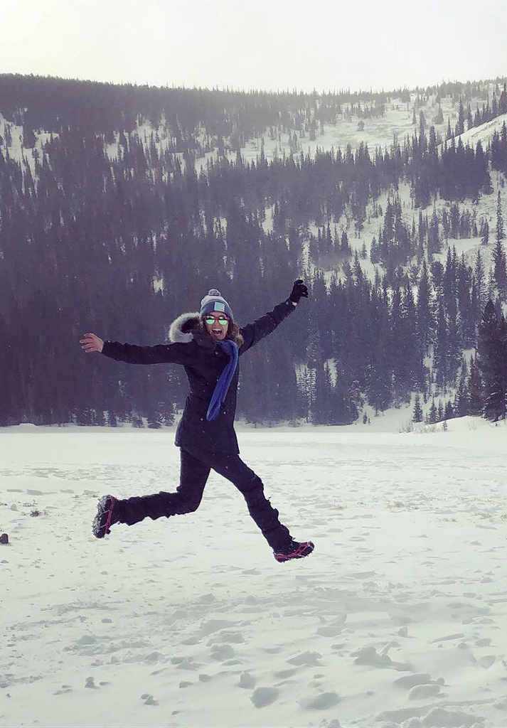 Mindy Sink excitedly jumps across the snow